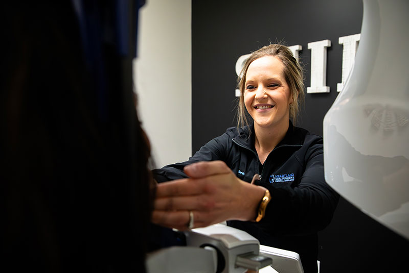 staff member helping patient with 3D scanning for dental procedure